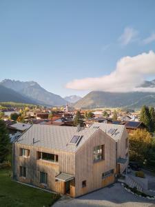 a house with a metal roof with mountains in the background at Haus Aerli in Ehrwald