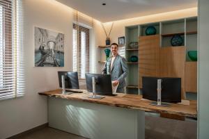 a man standing in front of a desk with two computers at Palazzo dei Guardiani in Venice