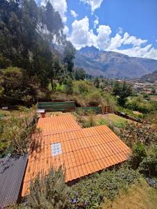 an orange tile roof with a bench in a field at Sevawasi in Cusco