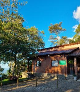 a brick building with trees in front of it at Casa na Rampa - Hospedagem no Caravaggio in Santa Teresa