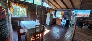 eine Küche und ein Esszimmer mit einem Tisch und einem TV in der Unterkunft cabaña en el bosque in Valle Hermoso + 9 Fotos