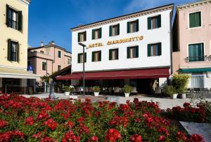 Ein Gebäude in einer Stadt mit roten Blumen. in der Unterkunft Hotel Giardinetto Venezia in Lido di Venezia