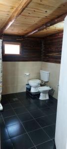 ein Badezimmer mit zwei Toiletten und einer Holzdecke in der Unterkunft cabaña en el bosque in Valle Hermoso