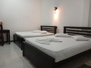 two beds sitting next to each other in a room at Yala Thaman Katharagama in Kataragama +43 photos
