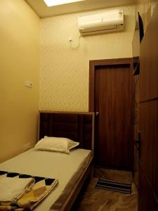 a bedroom with a bed and a air conditioner on the wall at Marquis Luxe Guest House in Kolkata +5 photos