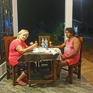 two older people sitting at a table with drinks at Yala Thaman in Kataragama