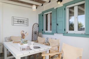 a dining room with green cabinets and a white table and chairs at Geronti Moscha Apartment in Apollonia