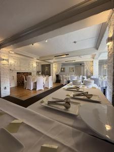 a dining room with white tables and white chairs at The Blue Anchor in Feering