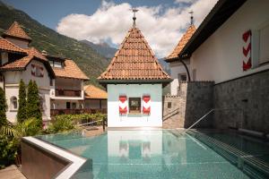 a swimming pool in a house with a mountain at Vitalpina Hotel Schulerhof in Plaus