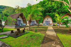 a resort with two bungalows and palm trees at Puri Garden Penida in Nusa Penida
