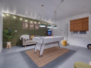 a living room with a ping pong table in it at Oxford - hot tub, games room, parking, arcade in Oxford