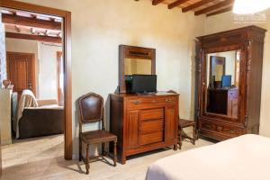 1 dormitorio con tocador, TV y espejo en Mugello Vacanze Appartamenti Indipendenti, en Scarperia