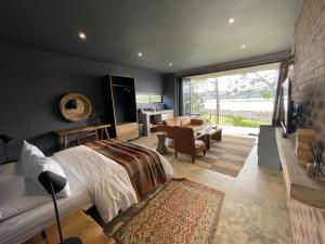 een slaapkamer met een bed en een woonkamer bij Bellevue on the Knysna lagoon in Knysna
