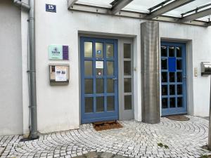 Un edificio con dos puertas azules en el lateral. en Rosis Appartement, en Wiener Neustadt