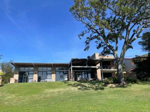 een huis met een boom ervoor bij Bellevue on the Knysna lagoon in Knysna