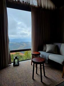 a living room with a couch and a large window at Chalé HOSPEDAGEM in Rio Bananal