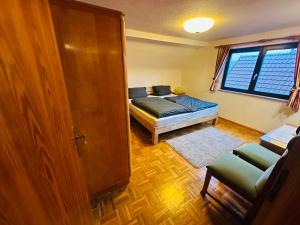 ein Schlafzimmer mit einem Bett und einer Couch und einem Fenster in der Unterkunft Ferienwohnung Marie in Kurort Steinbach-Hallenberg