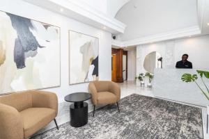 a man standing in a lobby with two chairs and a table at The Burg Collection - Suite 2 in Cape Town