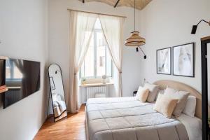 a white bedroom with a bed and a window at Comfortable Lux apartments near the Colosseum - Rome in Courmayeur