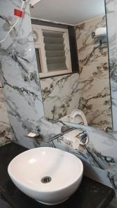 a bathroom with a white sink and a mirror at Marquis Luxe Guest House in Kolkata
