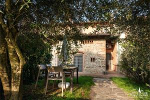 Una mesa y sillas frente a una casa en Mugello Vacanze Appartamenti Indipendenti, en Scarperia