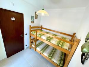 2 Etagenbetten in einem Zimmer mit einer Tür in der Unterkunft Casa Tété in Benagil