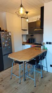 a kitchen with a wooden table with chairs and a refrigerator at Maison Brunet in Aime La Plagne