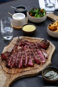 a table with a cutting board with meat and french fries at Radisson Collection Grand Place Brussels in Brussels