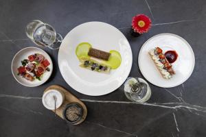 a table with plates of food and glasses of wine at Radisson Collection Grand Place Brussels in Brussels