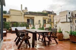 a wooden table and chairs on a patio at Comfortable Lux apartments near the Colosseum - Rome in Courmayeur