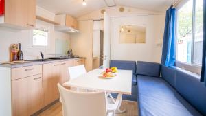 une cuisine et un salon avec une table et des chaises dans l'établissement Happy Camp mobile homes in Centro Vacanze Bi Village, à Fažana
