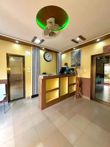 a lobby with a clock and a man sitting at a desk at hotel confort by freeman in Palimé
