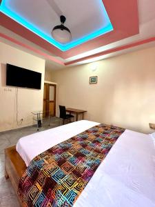 a bedroom with a bed and a flat screen tv at hotel confort by freeman in Palimé