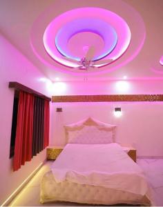 a bedroom with a large bed with a purple ceiling at The grandfarm resort in Kālwāra