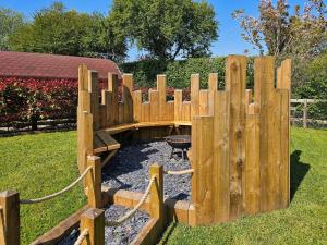 a wooden fence in a yard with a grill at Glamping Pod 1 in Ipplepen