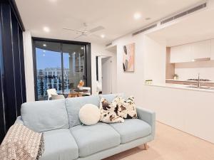a living room with a couch and a kitchen at RiverView Breeze Hamilton 3B2B with Free Parking in Brisbane