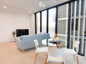 a living room with a couch and a table and chairs at RiverView Breeze Hamilton 3B2B with Free Parking in Brisbane