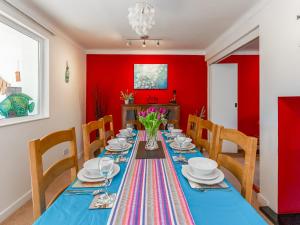 a dining room with red walls and a table with chairs at Applepips in Stirling +19 photos