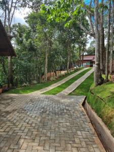 a walkway in a park with trees and grass at Chalé na Rampa - Hospedagem no Caravaggio in Santa Teresa +7 photos