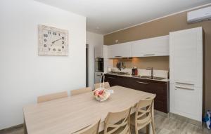 a kitchen with a table and a clock on the wall at 2 Bedroom Beautiful Apartment In Marzamemi in Marzamemi
