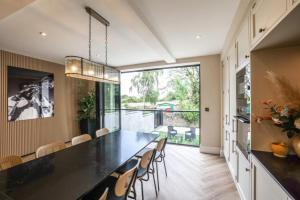 une salle à manger avec une grande table et des chaises noires dans l'établissement Oak Dene By Birch Stays, à Disley