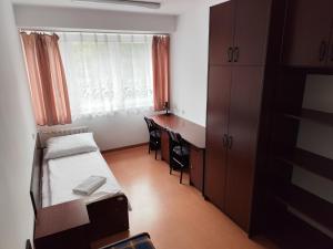 a small room with a bed and a desk and a window at Dom Studenta nr 2 in Siedlce