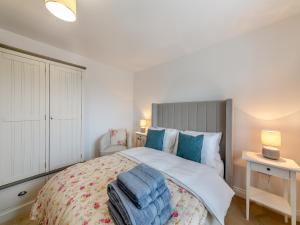 a bedroom with a large bed with blue towels on it at Curlew Retreat - Uk46780 in Ellington +12 photos