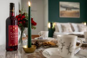 eine Flasche Wein auf einem Tisch mit einer Kerze in der Unterkunft Reindeer Dream Suite - Central Rovaniemi in Rovaniemi