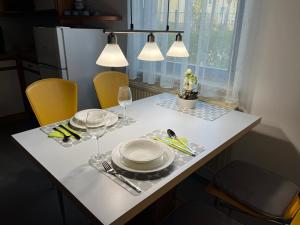 Una mesa con platos y copas de vino encima. en Rosis Appartement, en Wiener Neustadt