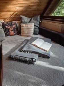 a bed with a tray with a book on it at Idyllisch & ruhig - gemütliches Ferienhaus im Wald Hunde willkommen, in Hatten, nahe Oldenburg in Hatten