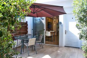 a patio with a table and chairs and an umbrella at Townhouse by the sea Pirate Harbor in Paphos City