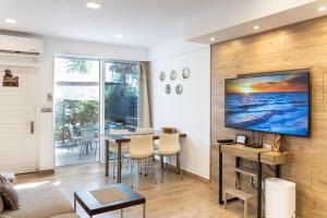 a living room with a table and a television on a wall at Townhouse by the sea Pirate Harbor in Paphos City
