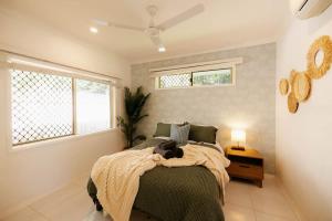 a bedroom with a bed with a cat laying on it at Seednest 7 bedroom beach house Pool &Game Room in Kewarra Beach