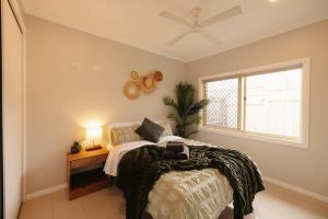 a bedroom with a bed and a window at Seednest 7 bedroom beach house Pool &Game Room in Kewarra Beach +41 photos